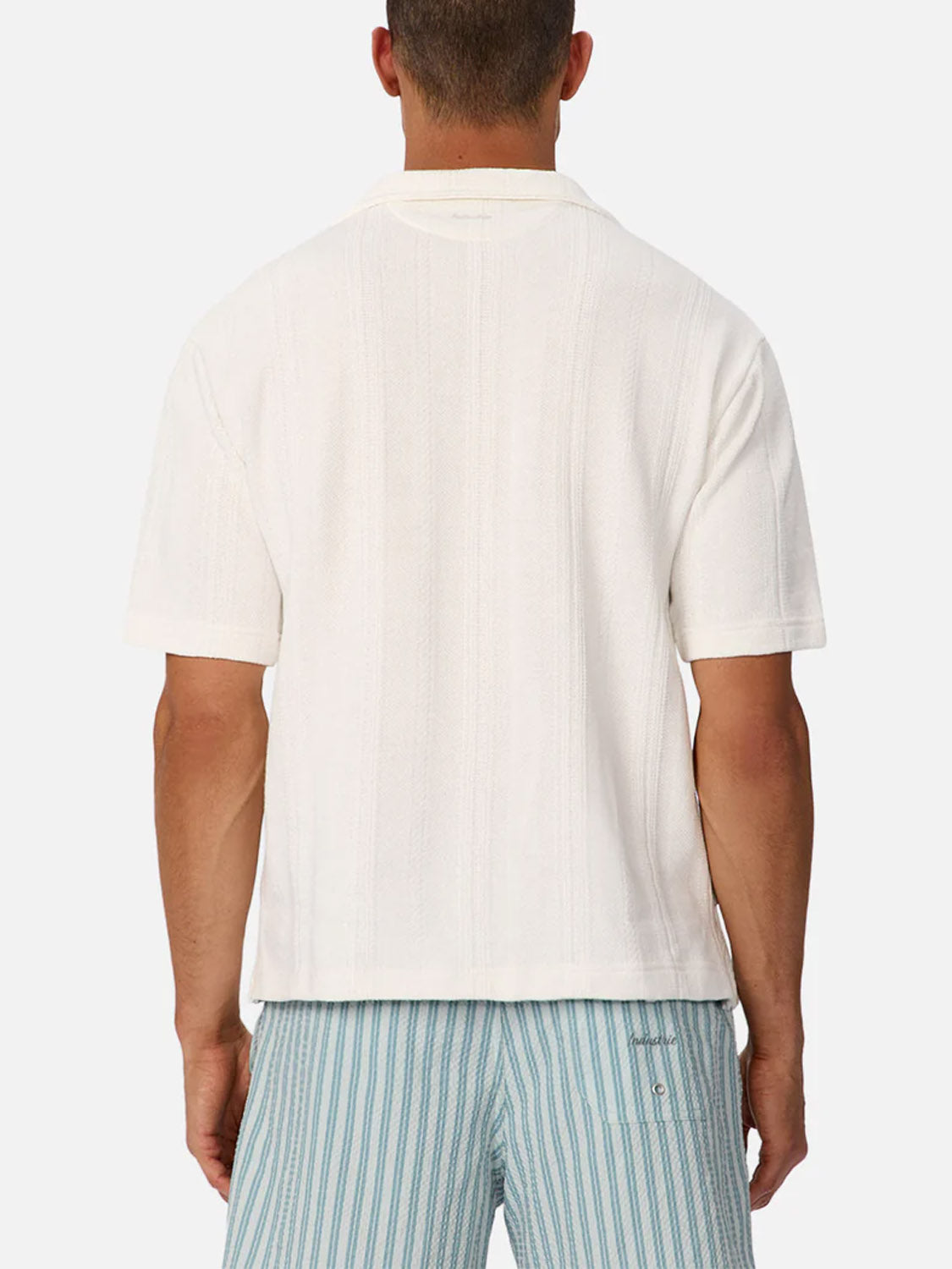A man is seen from the back wearing the Industrie Malaga Short Sleeve Shirt in white and light blue striped shorts, set against a plain white background.