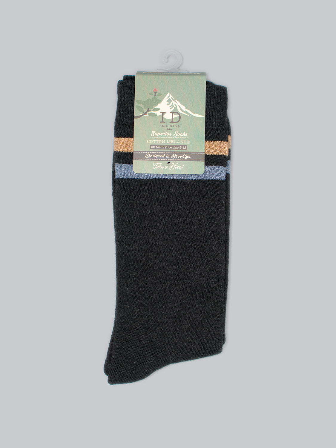 A pair of Rutland Cotton Melange Socks by ID Menswear, featuring tan and blue stripes on dark cotton against a light gray background. Packaging includes a small mountain illustration and text promoting their Cotton Melange finish.