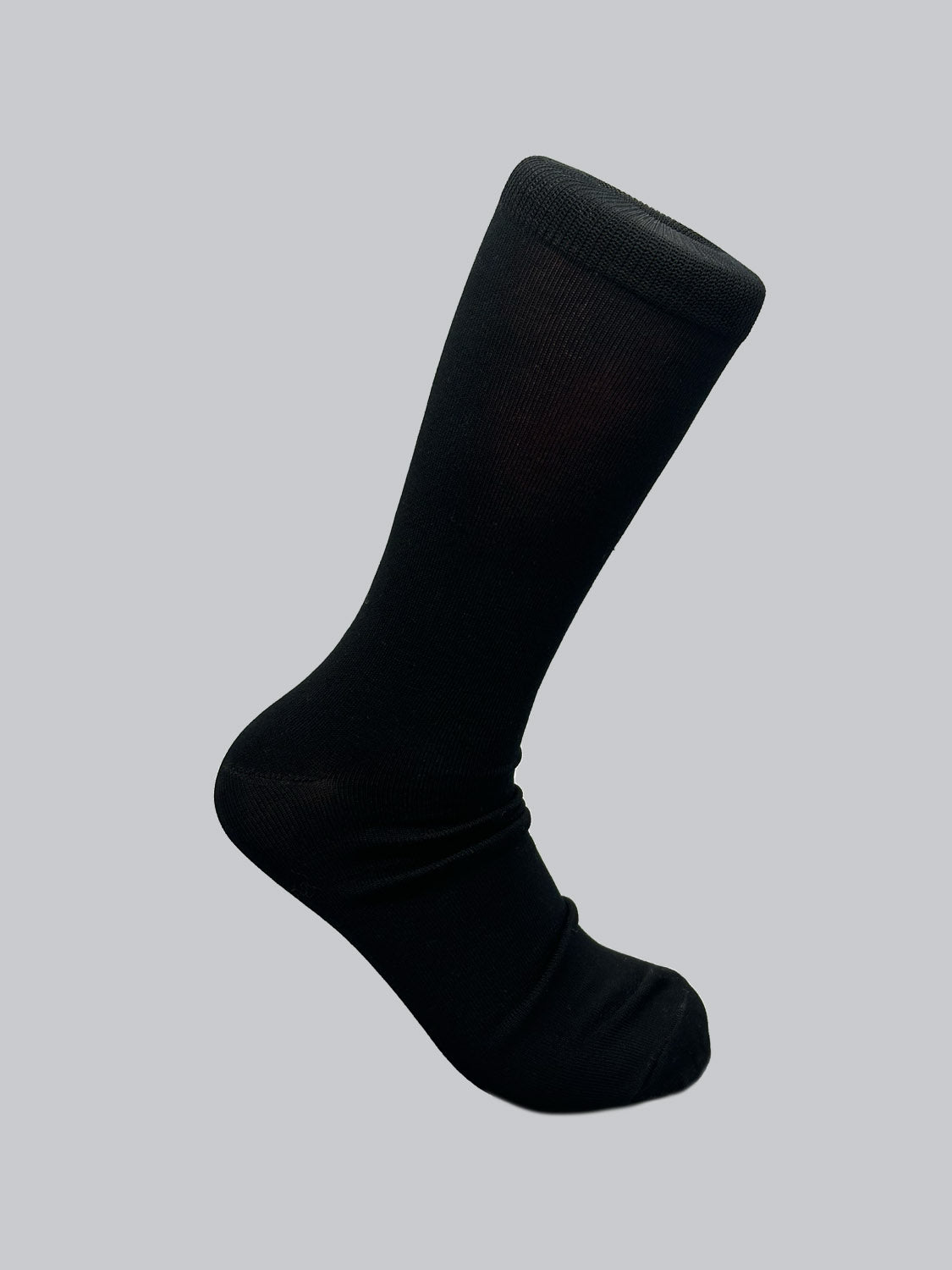 A single sock from ID Menswears Mercerized Cotton Socks collection, made of luxurious black mercerized cotton, stands upright on a grey background, showcasing its full length from cuff to toe.