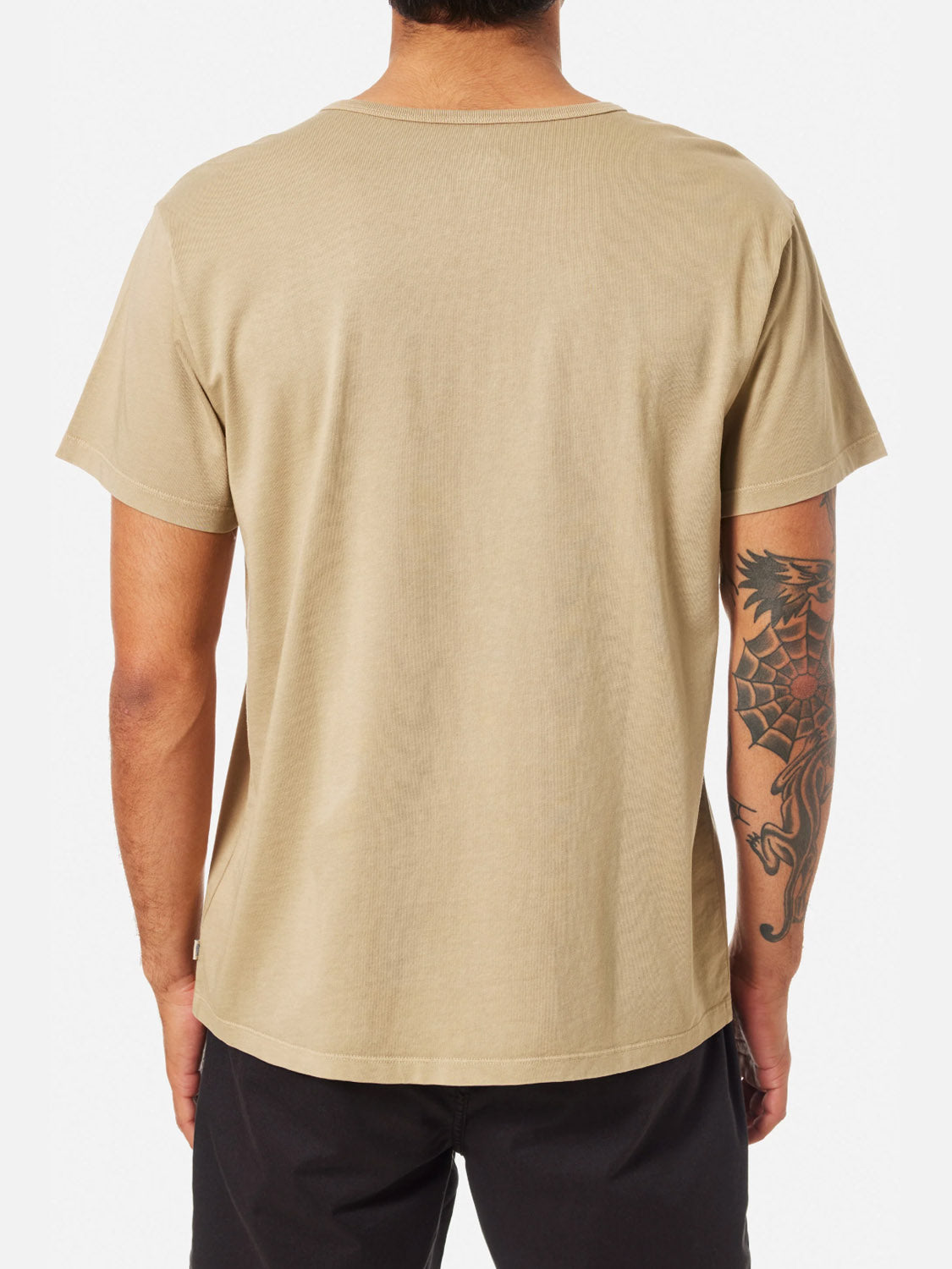 A person is shown from the back wearing the Katin Mesa Henley in beige and black pants, with a large dragon tattoo on their right arm.