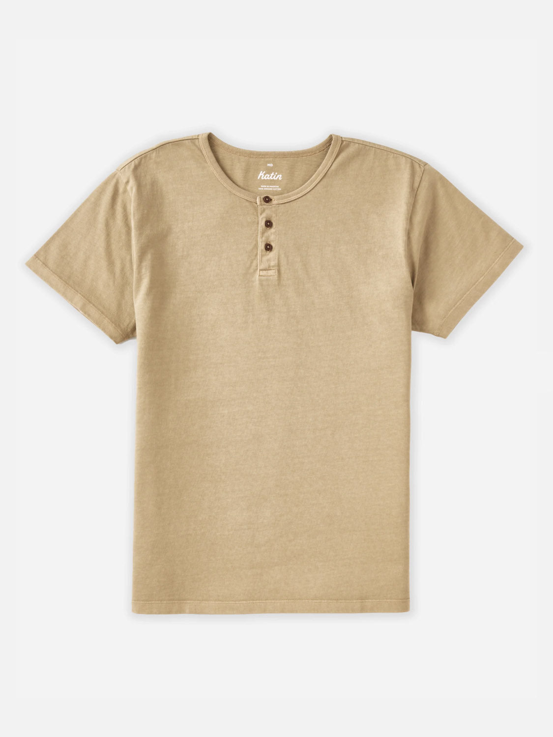 The Katin Mesa Henley is a plain, beige men's short-sleeve t-shirt made from organic cotton with a round neckline and three brown buttons, shown laid flat on a white background.