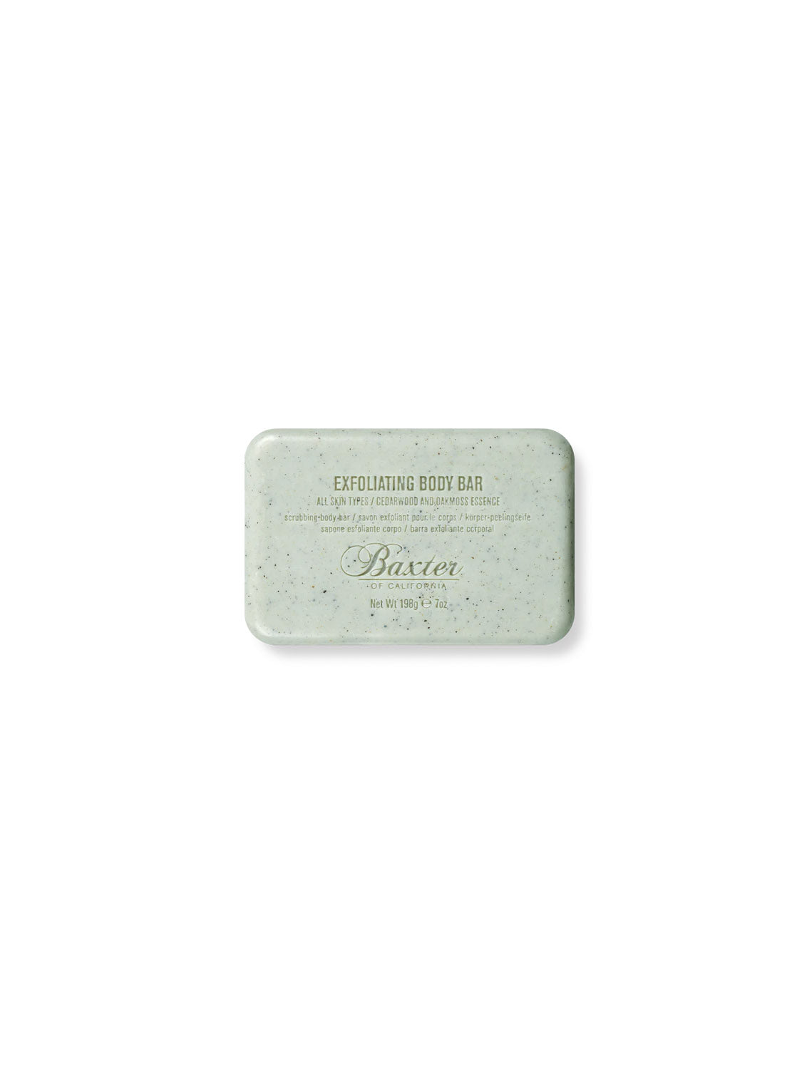 Baxters Exfoliating Mini Body Bar, a rectangular pale green soap perfect for men, is centered on a white background. With black specks, it showcases text branding and ingredient details in light gray, highlighting its cedarwood & oakmoss fragrance.