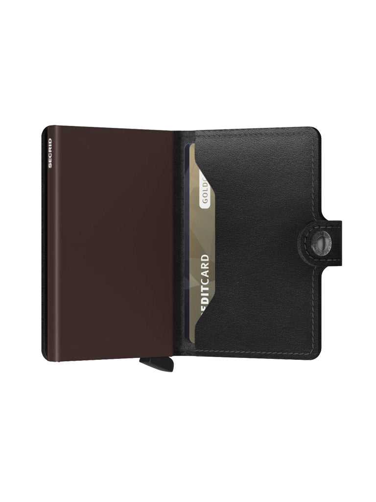 The Secrid Miniwallet Original by Secrid is an open compact wallet crafted from European leather with a snap closure, featuring RFID security. A gold credit card sits in the right slot while the left side displays its sleek, minimalist design.