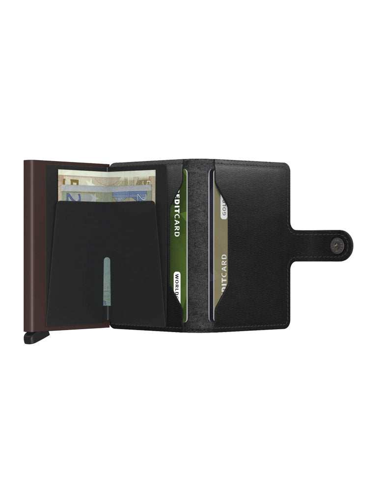 The Secrid Miniwallet Original by Secrid is an open black compact wallet made from European leather, with multiple card slots, two green MULTICARD cards displayed, a euro banknote compartment, and a snap closure flap.