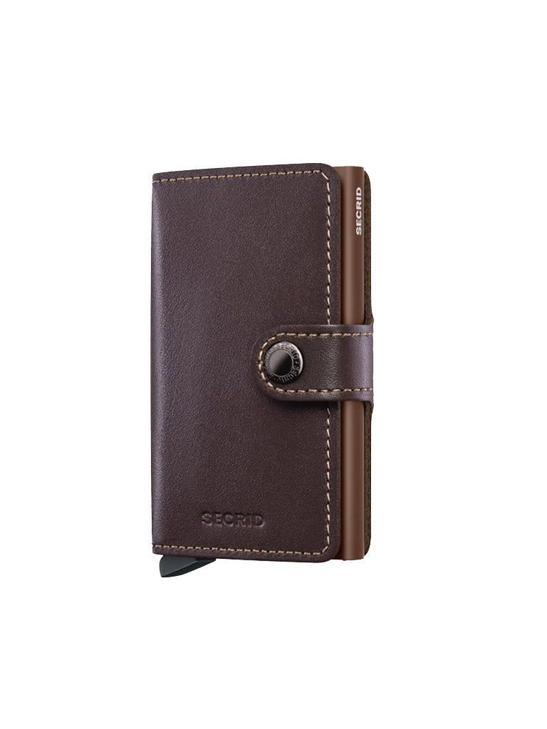 The Secrid Miniwallet Original is a dark brown European leather wallet with visible stitching, snap button closure, and slim design. SECRID is embossed on the front, combining style with RFID security.