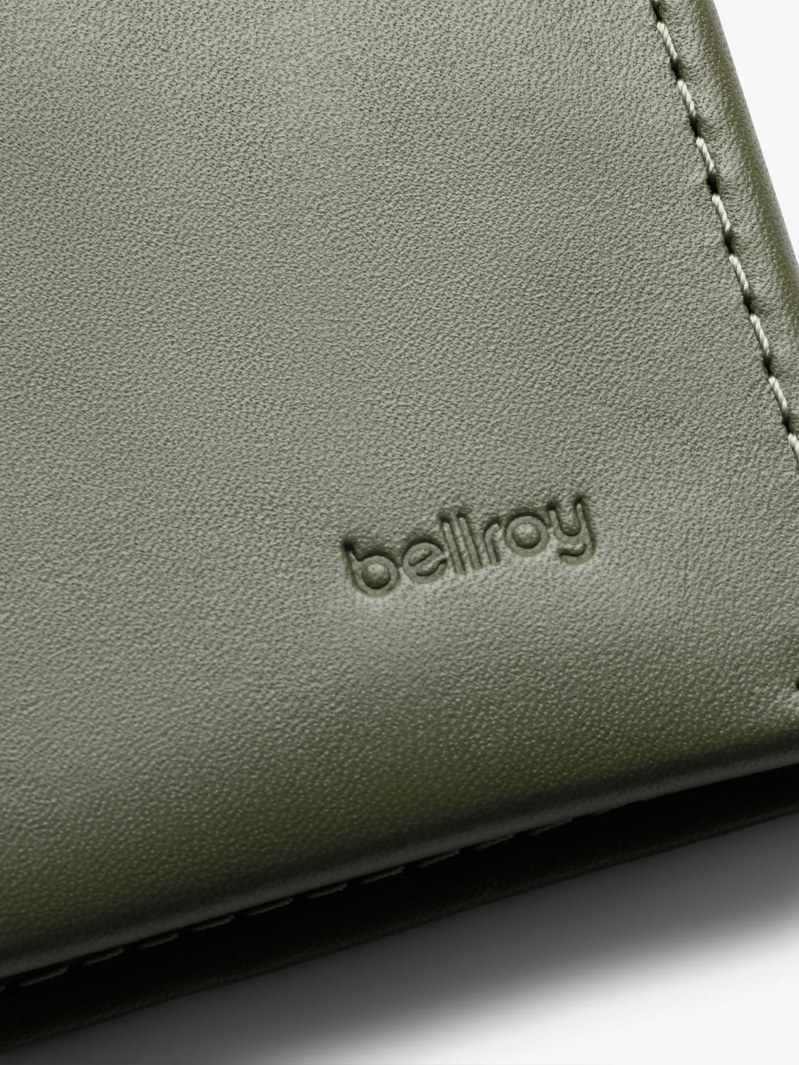 Close-up of a Note Sleeve Wallet by Bellroy in olive green leather with RFID protection, embossed brand name, and visible edge stitching.
