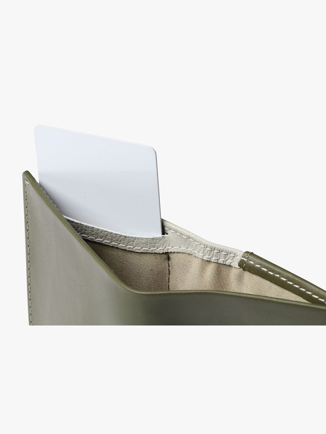 A close-up of the Bellroy Note Sleeve Wallet in green with RFID protection, showing a white card partly visible in the outer pocket.