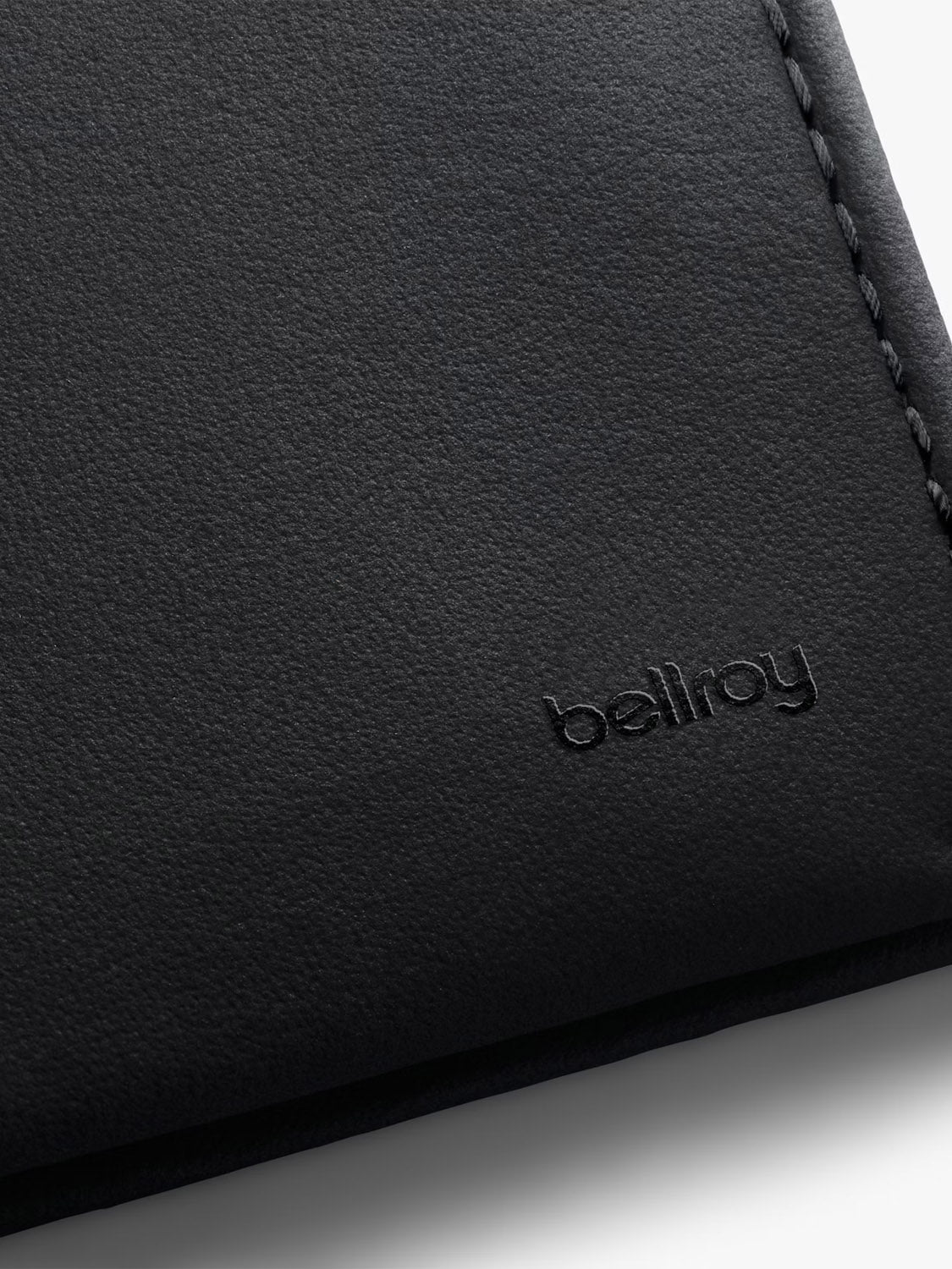 Close-up of the Bellroy Note Sleeve Innovera™ Edition, a black leather wallet with visible stitching and the brand name embossed in the lower right corner, featuring RFID protection for enhanced security.