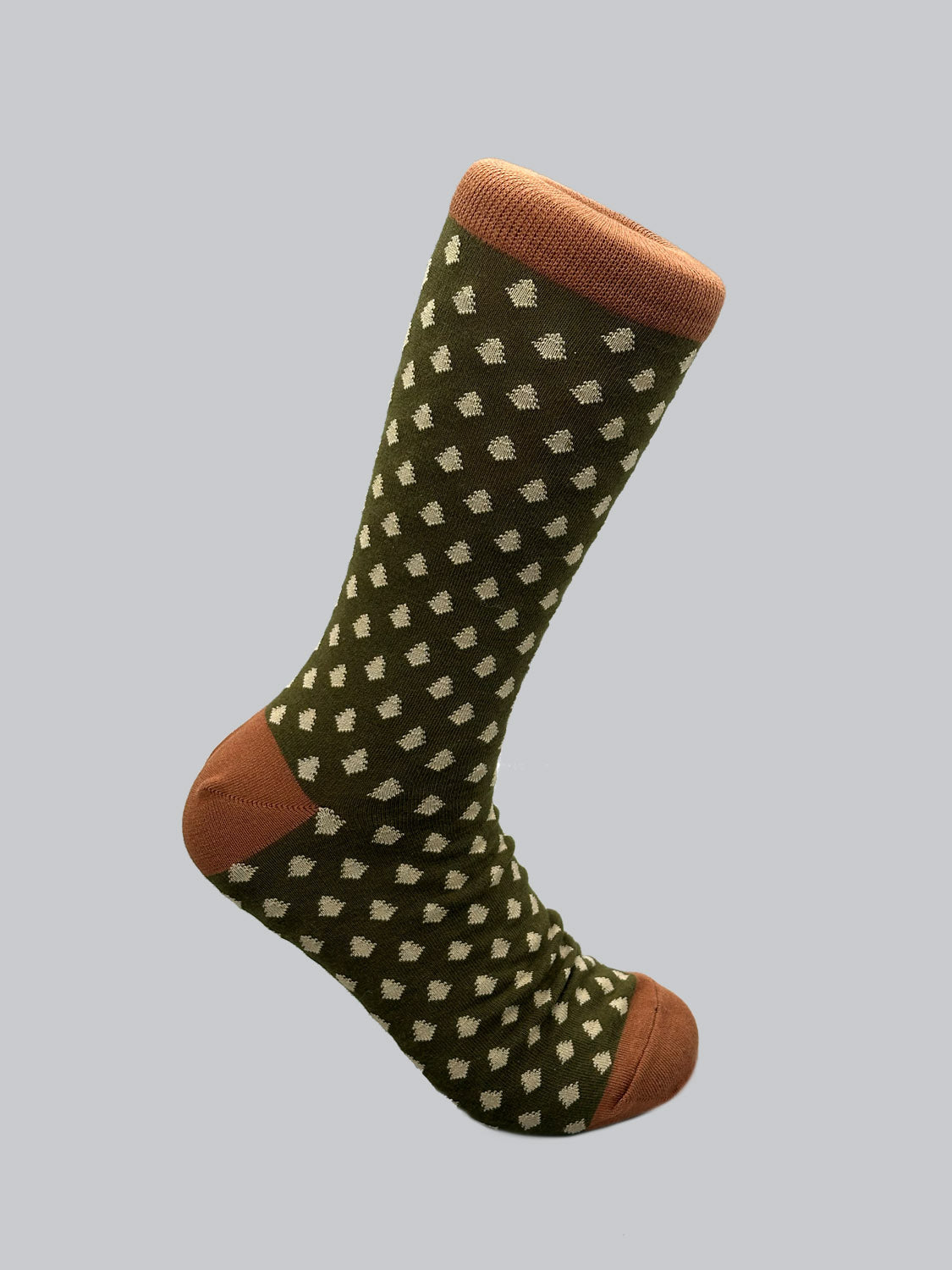 The Ogawara Graphic Sock from ID Menswear is a single knee-high, premium combed cotton sock with an olive green backdrop and white dots. The brown toe and cuff provide contrast, while its breathable and stretchy fabric is showcased against a light gray background.