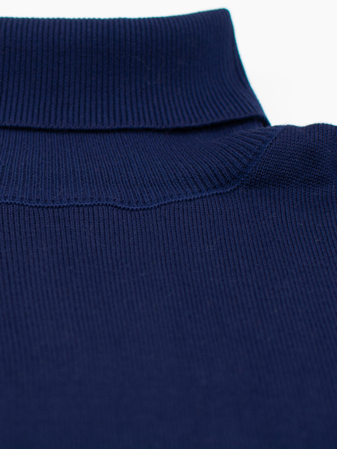 Close-up of an ID Menswear Oregon Viscose Turtle Neck sweater in navy blue. The ribbing and soft texture enhance the collar and shoulder area, making it ideal for everyday wear. The fabric appears comfortable and refined.