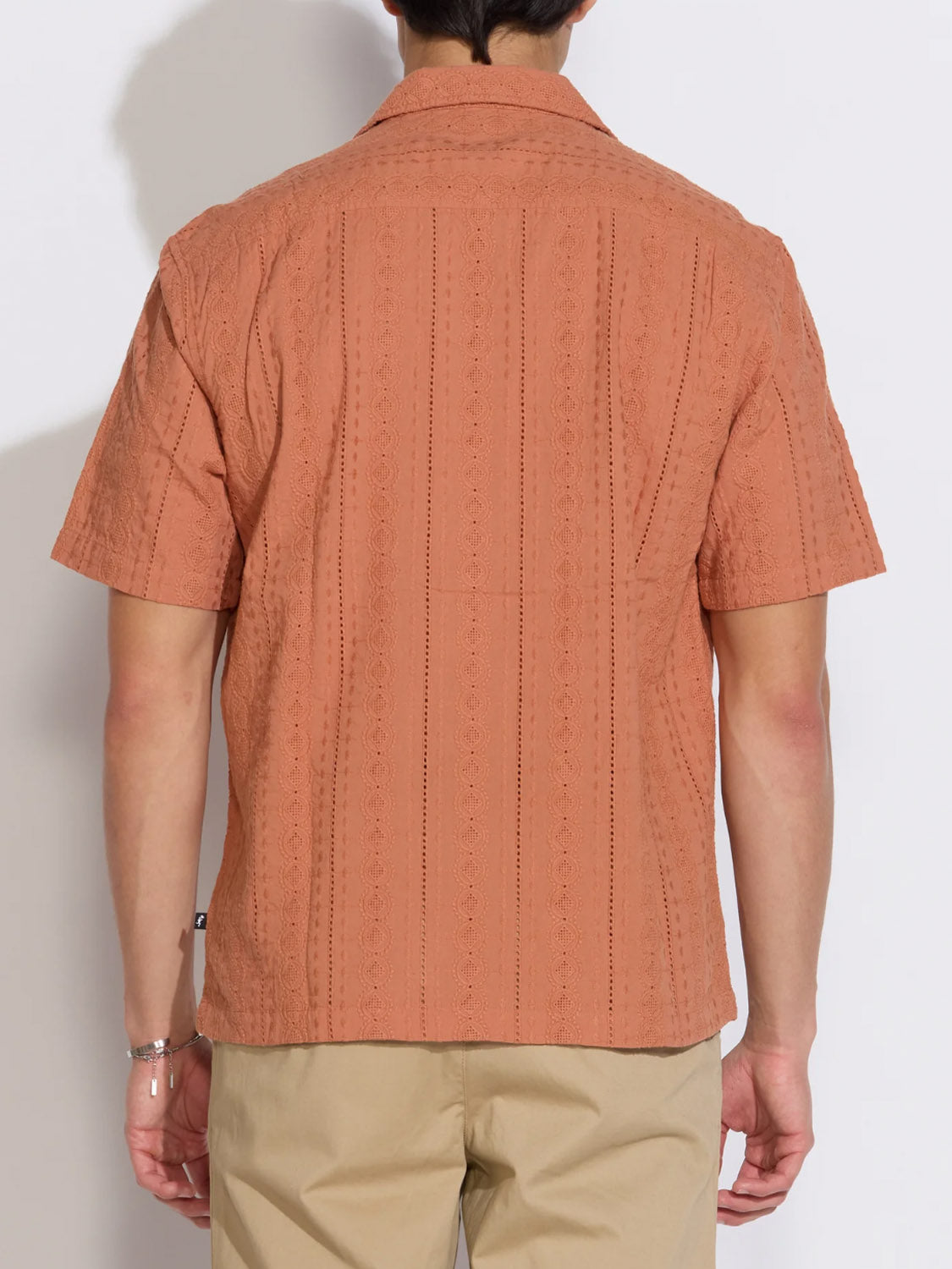A person is seen from the back against a plain white background, wearing the Civil Society Palomino Relaxed Fit Pocket Resort Shirt in light brown with beige pants.
