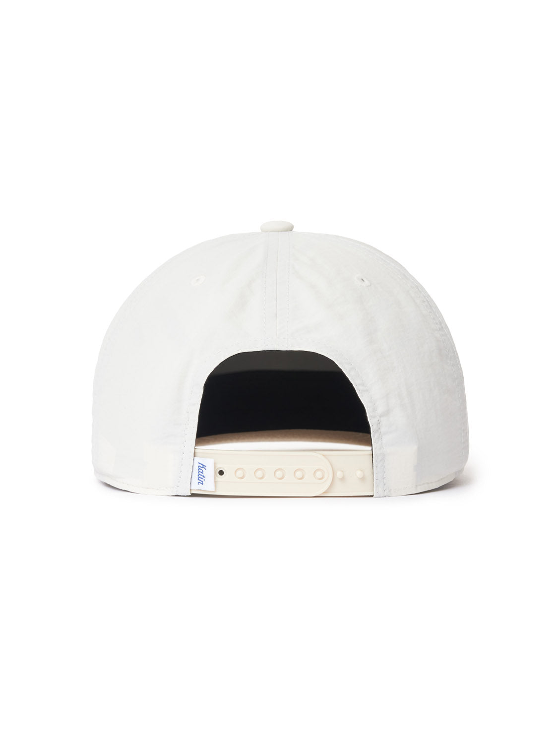 The Katin Pina Nylon Hat, shown from the back in white, features a soft, rounded crown and an adjustable beige snapback strap with plastic fasteners and a fabric loop. Its classic design is reminiscent of Katin headwear.