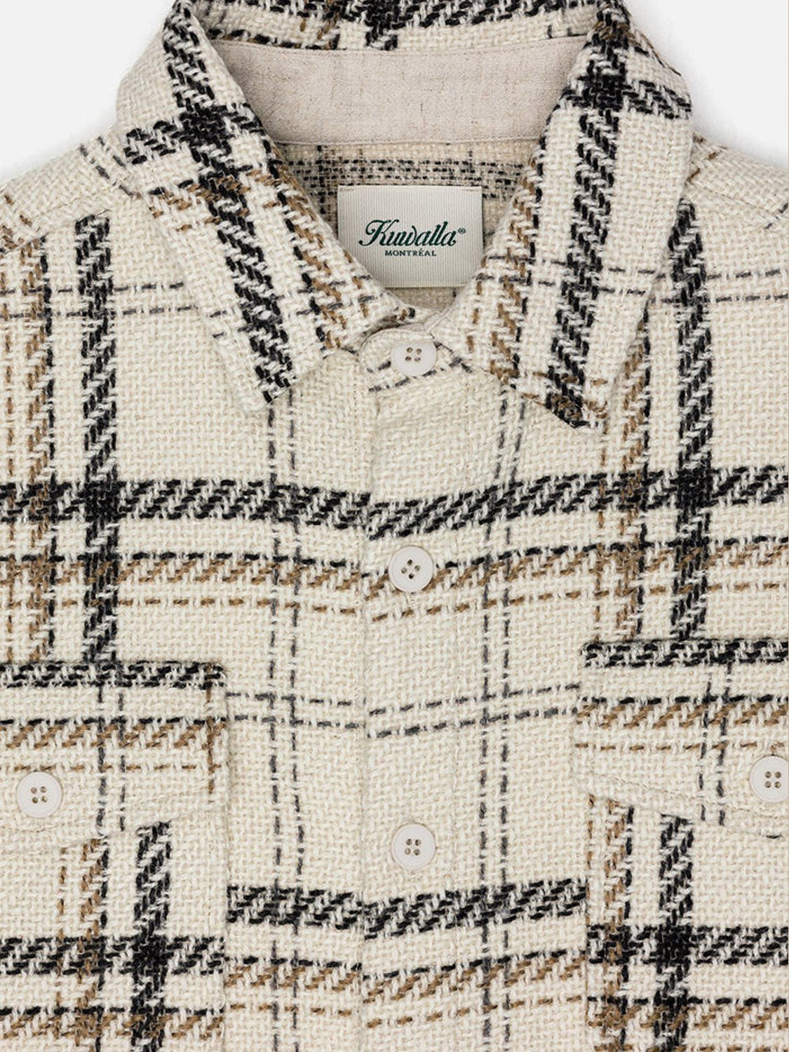 Close-up of a plaid shirt with a brand label on a white background