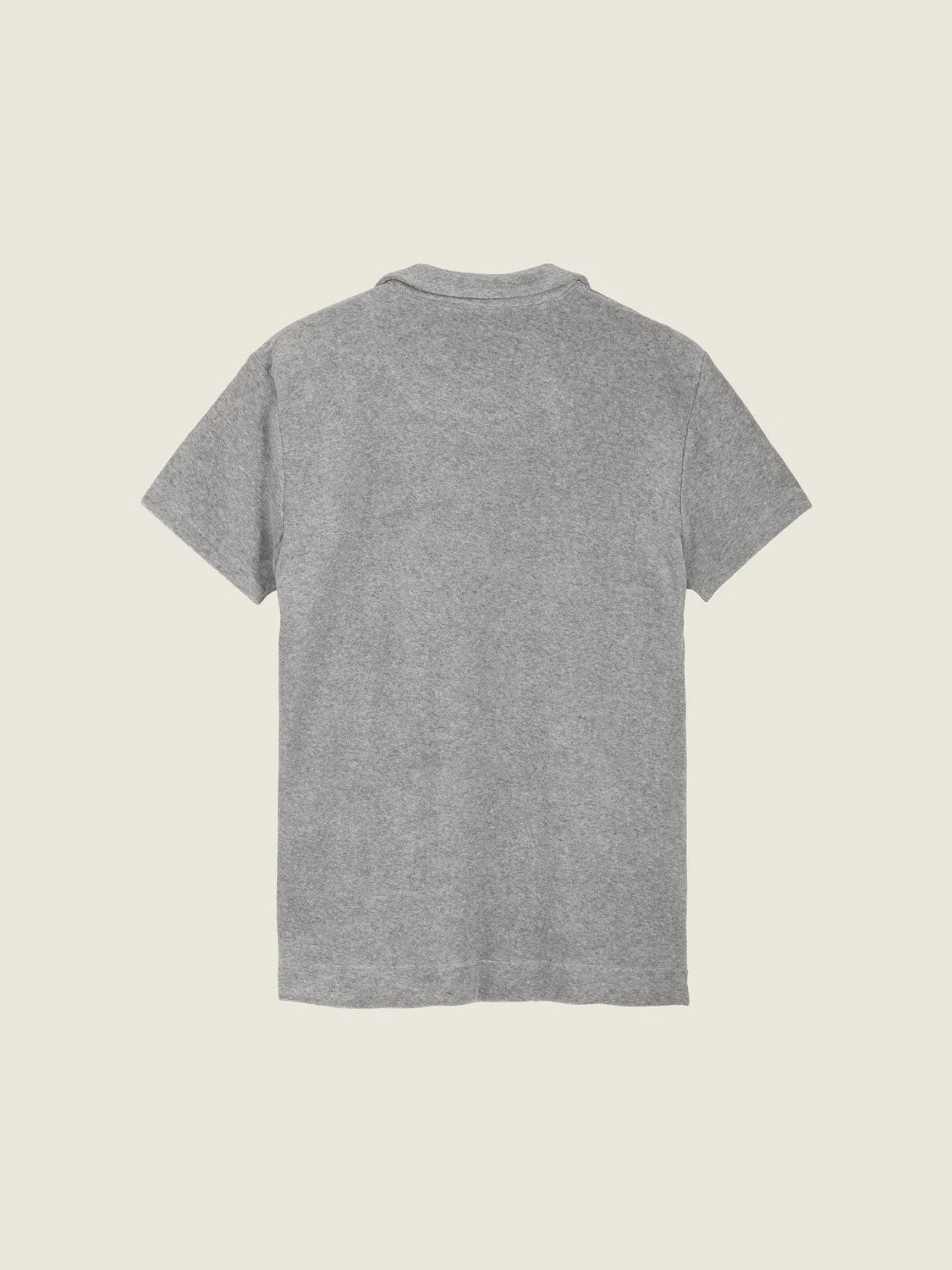 The OAS Polo Terry Shirt, shown from the back, is a plain gray short-sleeve shirt made from breathable cotton terrycloth and displayed against a light beige background.