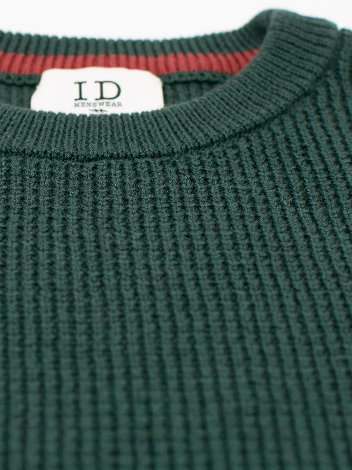 Close-up of the green Ragnar Waffle Knit Sweater by ID Menswear, showcasing its ribbed texture and cozy 100% cotton fabric. It features a crew neckline with red interior trim.