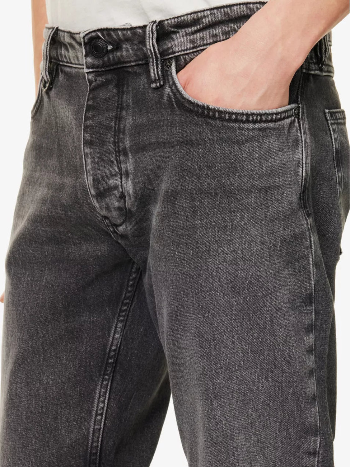 A person wearing Neuw Ray Straight Dead Moon high-waisted comfort stretch jeans in faded black, hand in front pocket, shown from waist to mid-thigh.