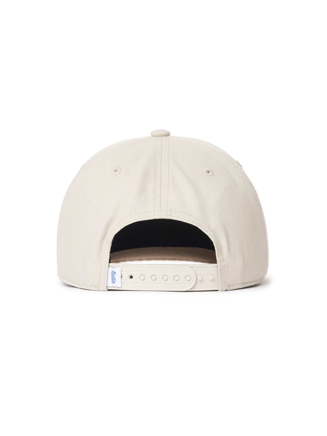 The Katin Reflection Twill Hat is a beige baseball cap made of smooth cotton twill, featuring a Snapback closure with plastic snaps. It includes a small tag on the left side near the strap opening, showcasing attention to detail.