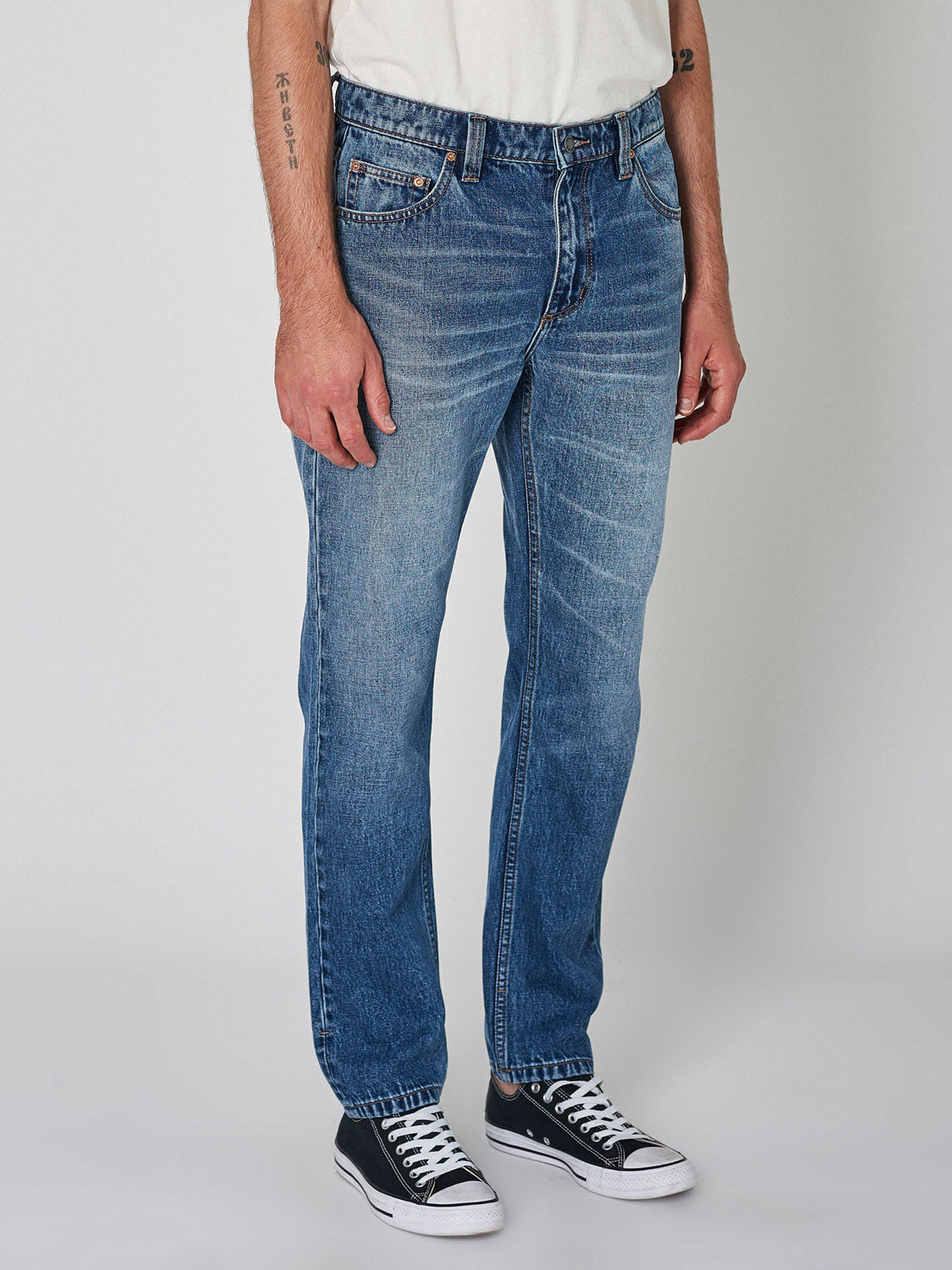 A person wearing Rollas Relaxo Hemp Blues Denim stands against a plain light gray background, with only their lower torso and legs visible.