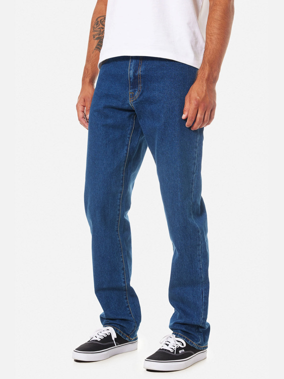 A man, visible from the shoulders down, stands against a plain white background wearing a white t-shirt, black-and-white sneakers, and Katin Ren 57 Classic Straight Pants with classic 5-pocket styling.