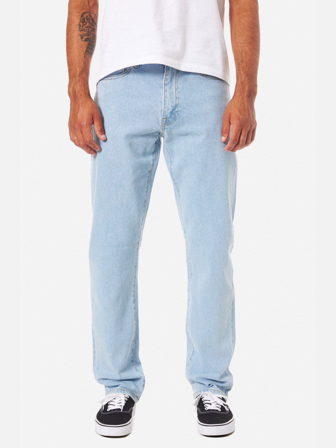 A person wears Katin Ren 57 Classic Straight Pants, styled with a white t-shirt and black-and-white sneakers, standing against a white background. Only their lower torso and legs are shown.