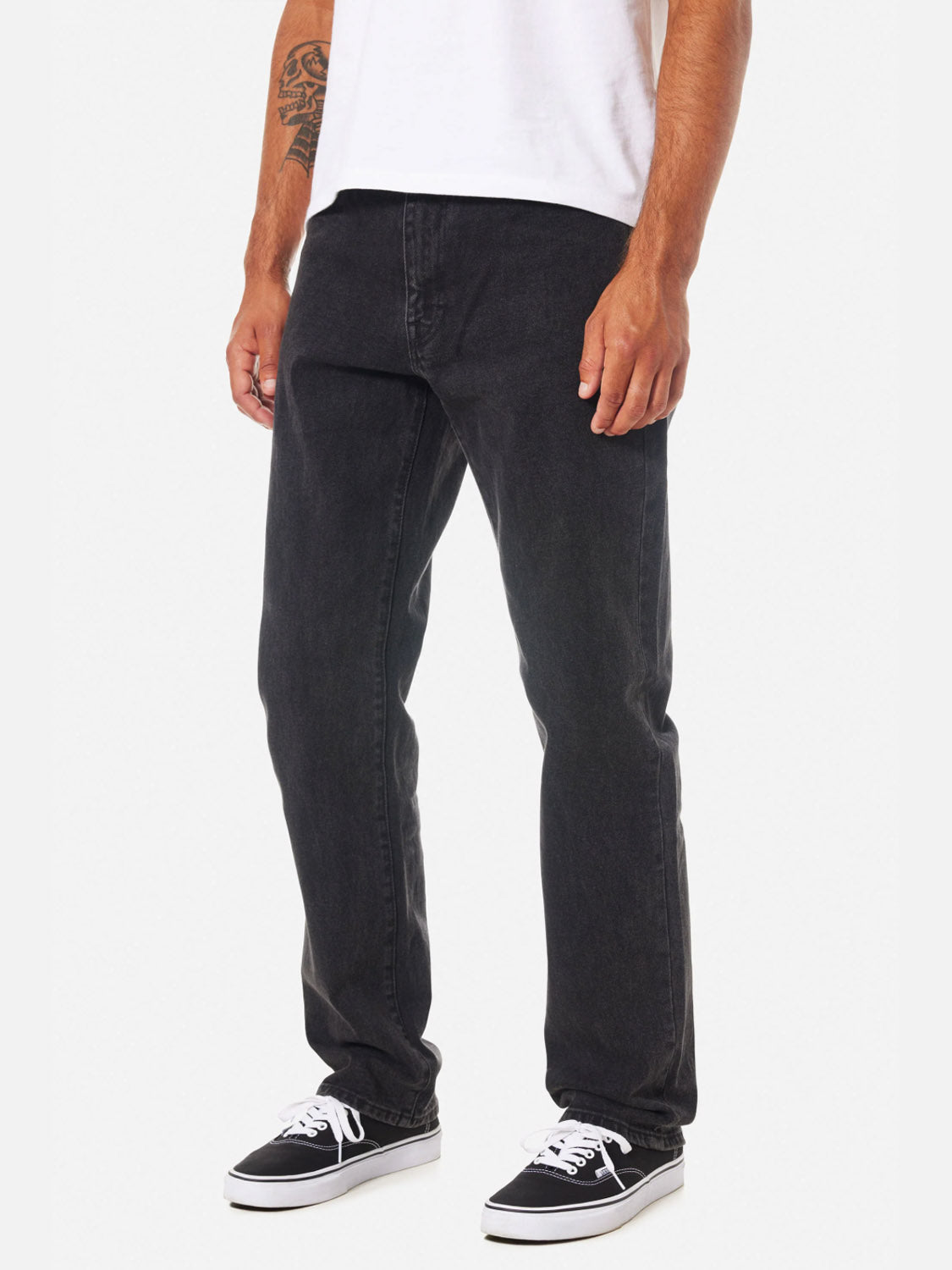 A person wearing a white T-shirt, Katin Ren 57 Classic Straight Pants with 5-pocket styling, and black sneakers with white soles stands against a plain white background, displaying a tattoo on their forearm.