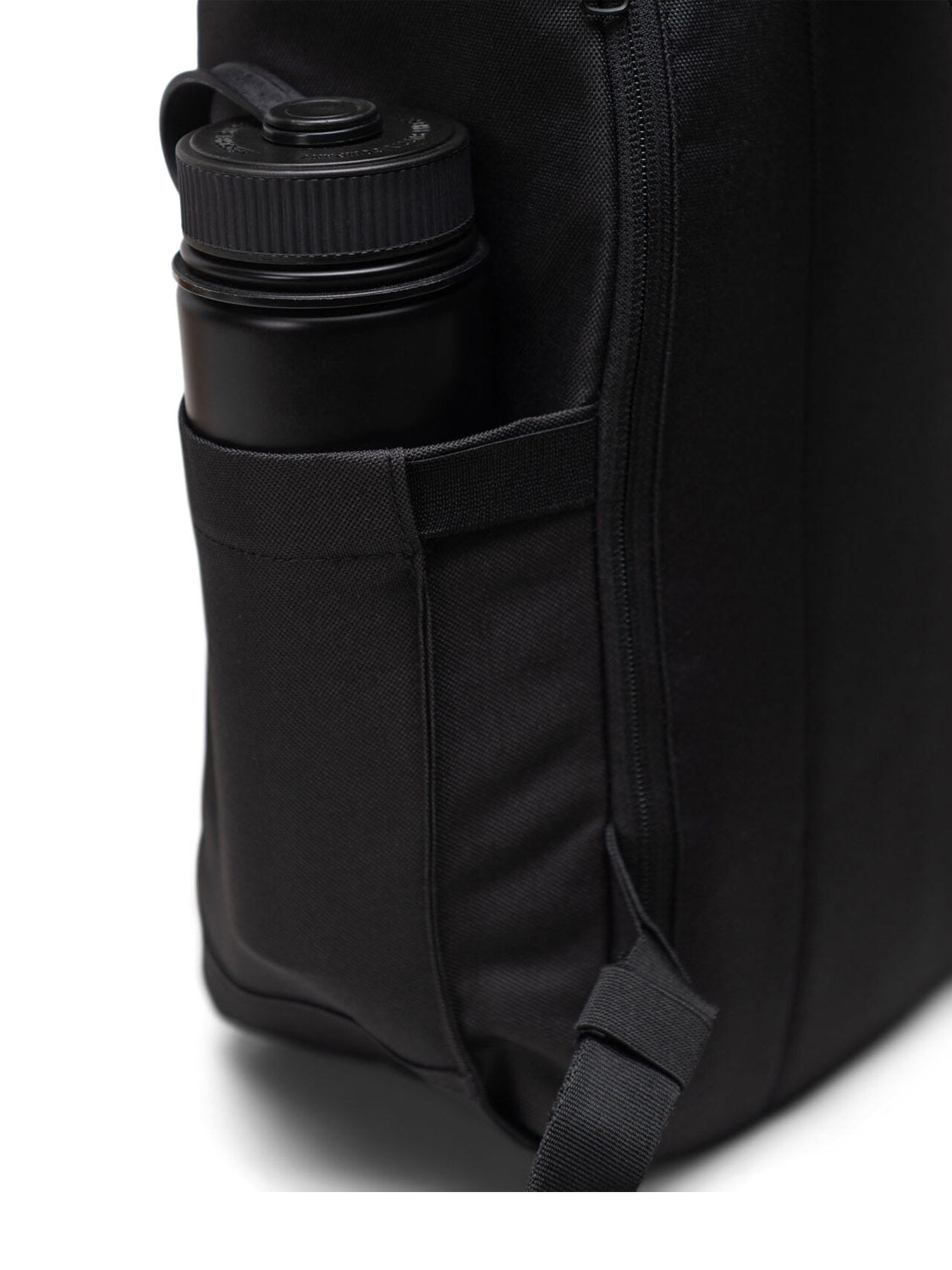 A black water bottle fits snugly in the side pocket of the eco-friendly Herschel Retreat Backpack, shown upright to highlight its sustainable design.