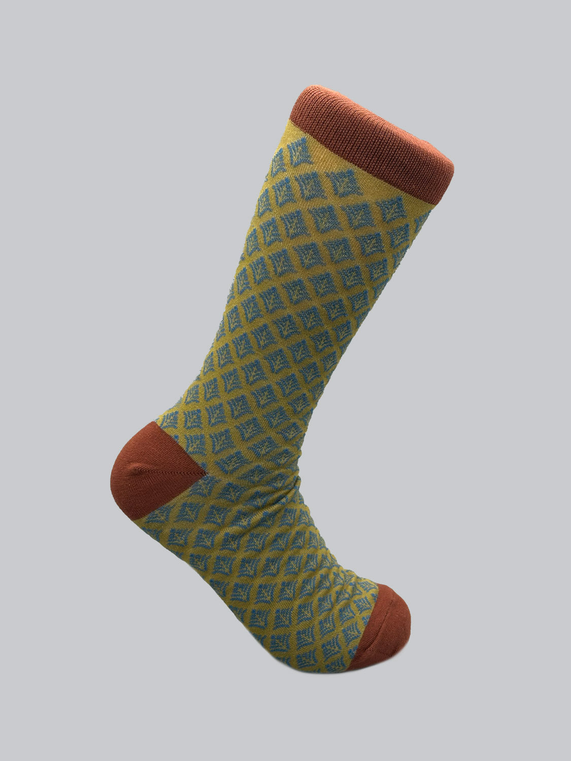 ID Menswears Retro Graphic Sock showcases a vintage-modern blend with its blue diamond pattern on yellow combed cotton, complemented by a reddish-brown toe, heel, and cuff against a plain backdrop.
