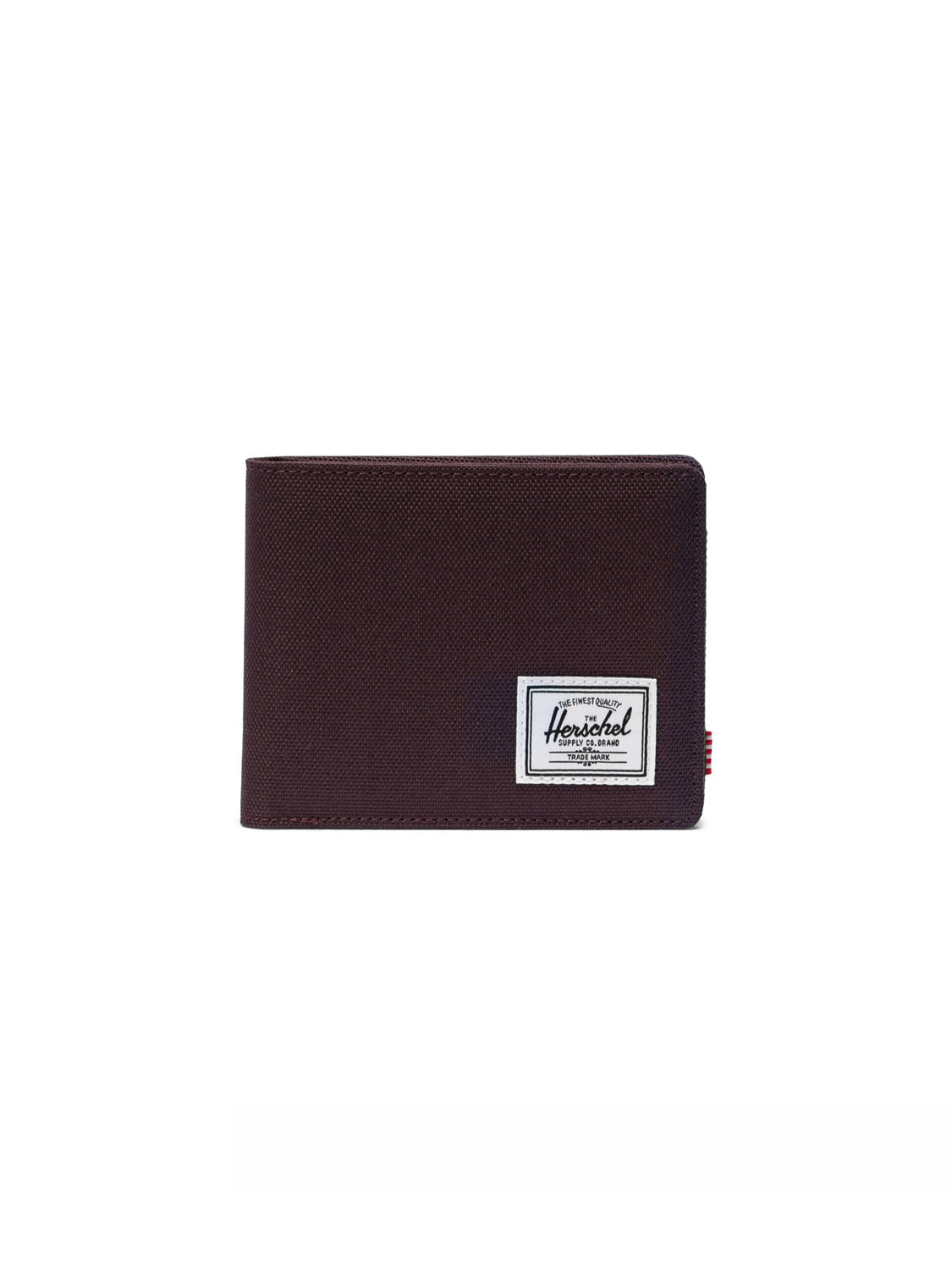The Herschel Roy Classic Folded Wallet, made from dark brown recycled polyester, is shown closed with a white brand label stitched on the lower right corner, displayed against a plain white background.