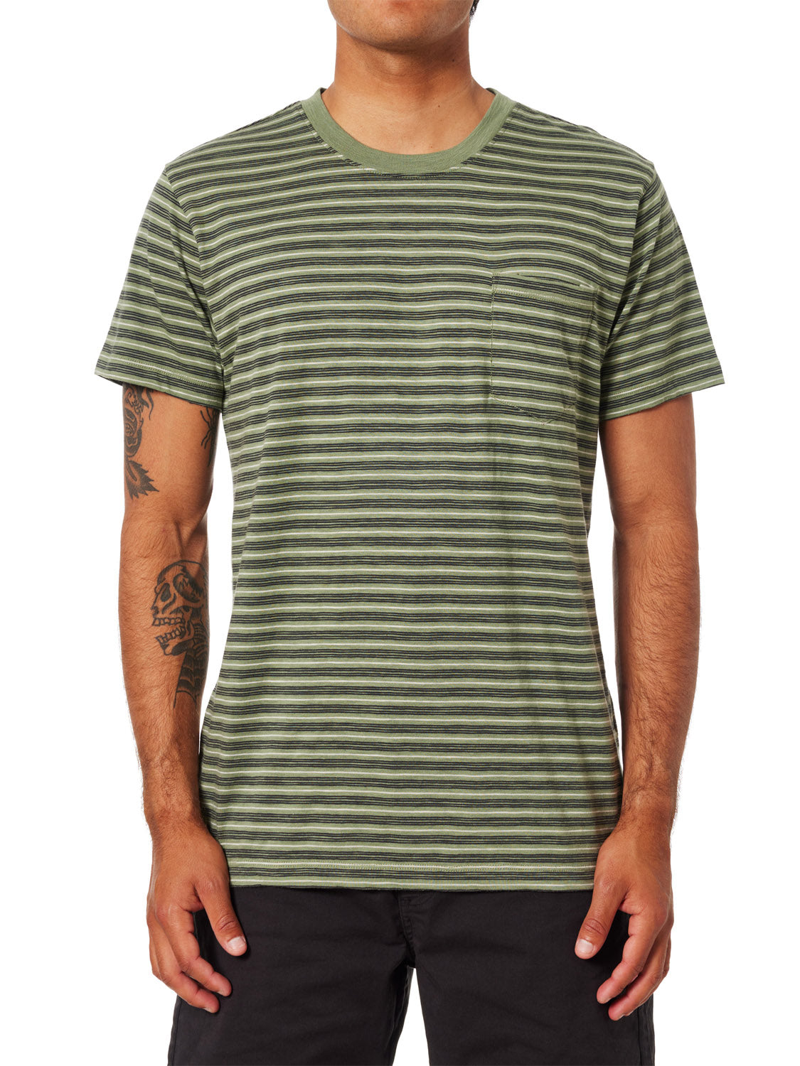 A forward-facing individual wears a green and black Katin Rural Pocket Tee made of premium cotton with a left chest pocket. Their forearms feature tattoos, theyre in black shorts, but their head is not visible.