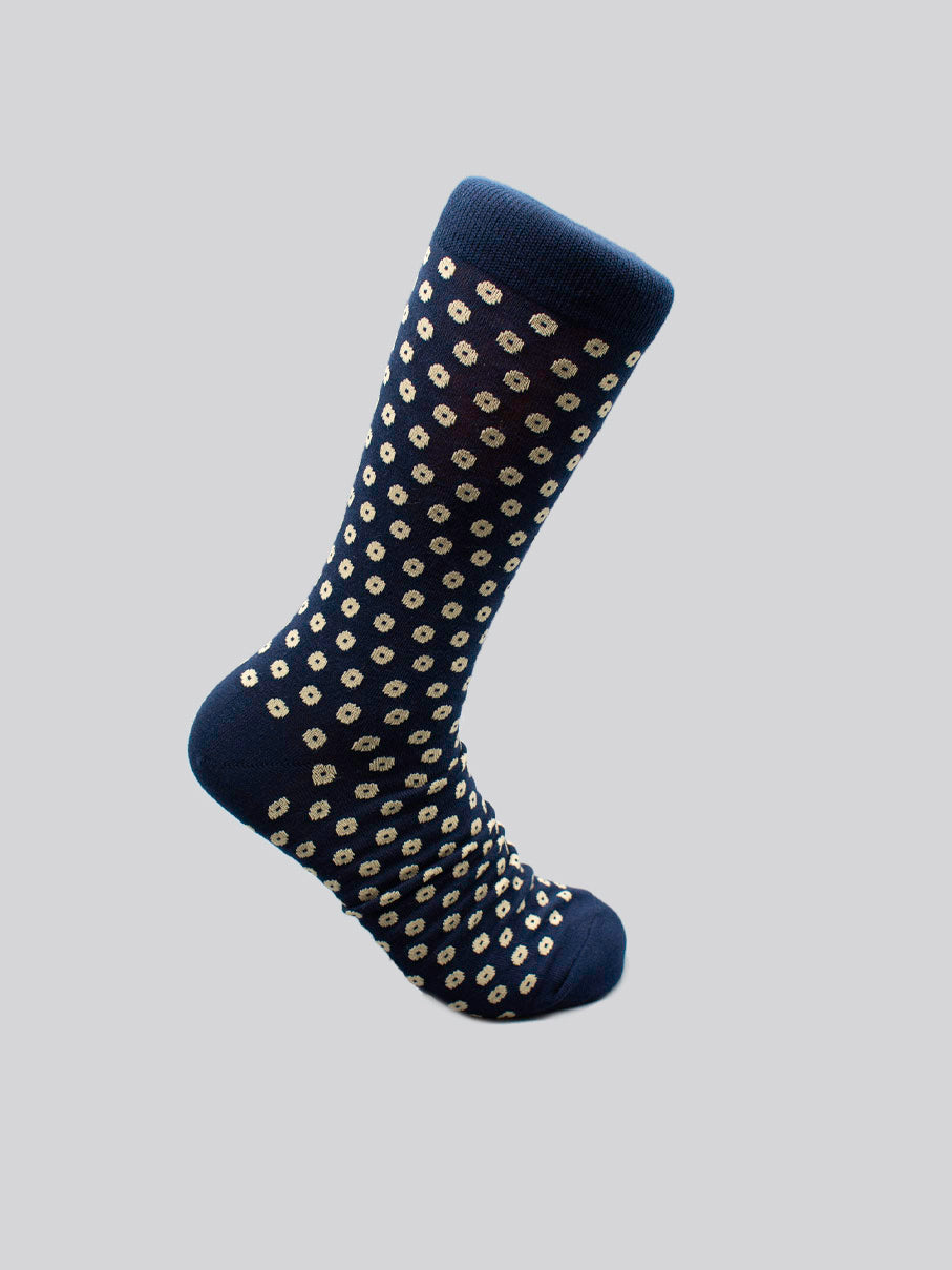 The Shibori Graphic Socks by ID Menswear are a limited edition, navy blue pair made from combed cotton, featuring small white dots and shown on a plain light gray background.