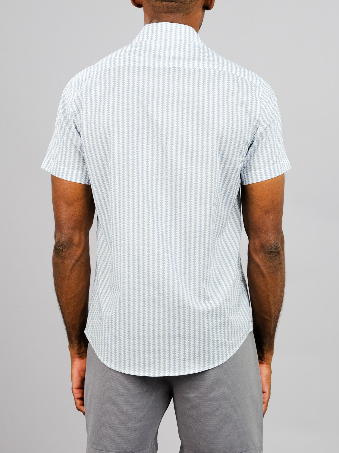 A person wearing the Shima Printed Cotton Shirt by ID Menswear in light blue and white, paired with gray shorts, is shown from the back against a plain light gray background.