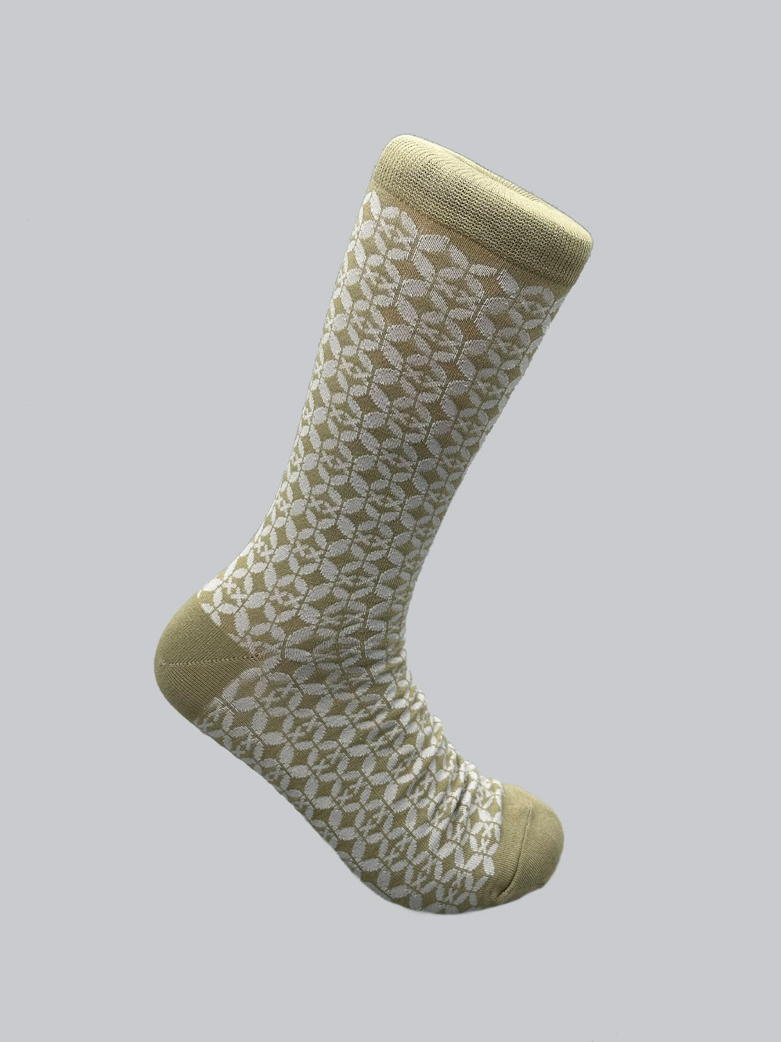 ID Menswears Shippo Graphic Socks feature a light gray leaf pattern on beige combed cotton, with solid beige toe, heel, and cuff. These comfortable socks are set against a plain light gray background.