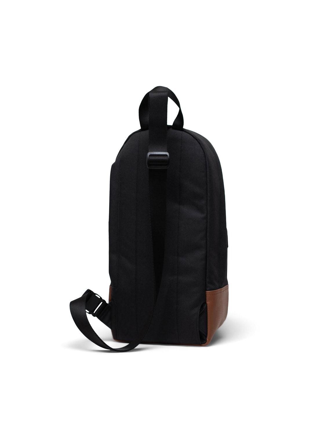 The Herschel Heritage Shoulder Bag is a black crossbody backpack with a single shoulder strap, brown leather accents at the bottom, and a top handle, shown on a plain white background.