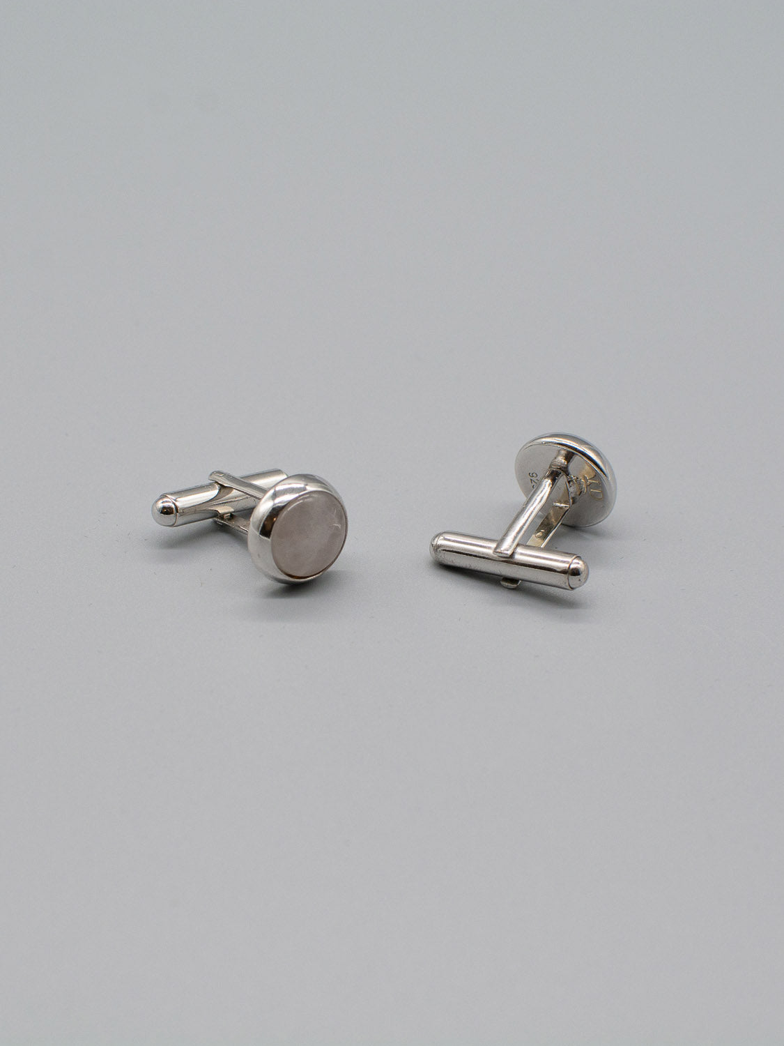 Two ID Menswear Rhodium Plated Silver Gemstone Cufflinks are on a gray background. One stands upright, the other lies flat, highlighting their sleek and simple design.