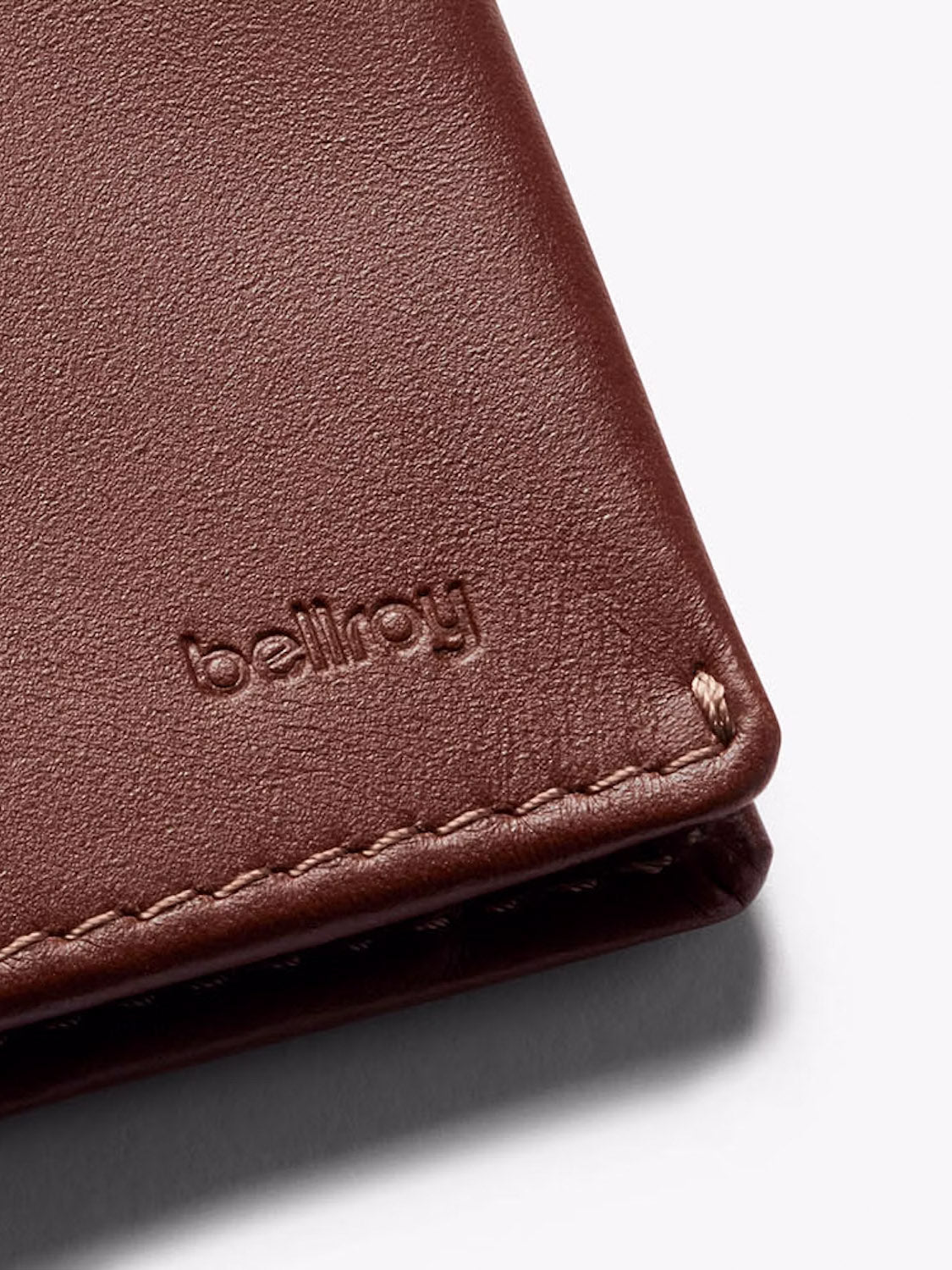 Close-up of a brown leather Slim Sleeve Wallet by Bellroy, featuring visible stitching and the embossed brand name, highlighting its compact, pocket-friendly design.