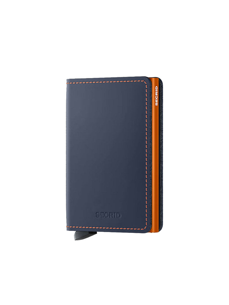 The Secrid Slimwallet Matte Finished Leather, in navy blue with orange edges and contrast stitching, is an RFID wallet shown standing upright against a white background.