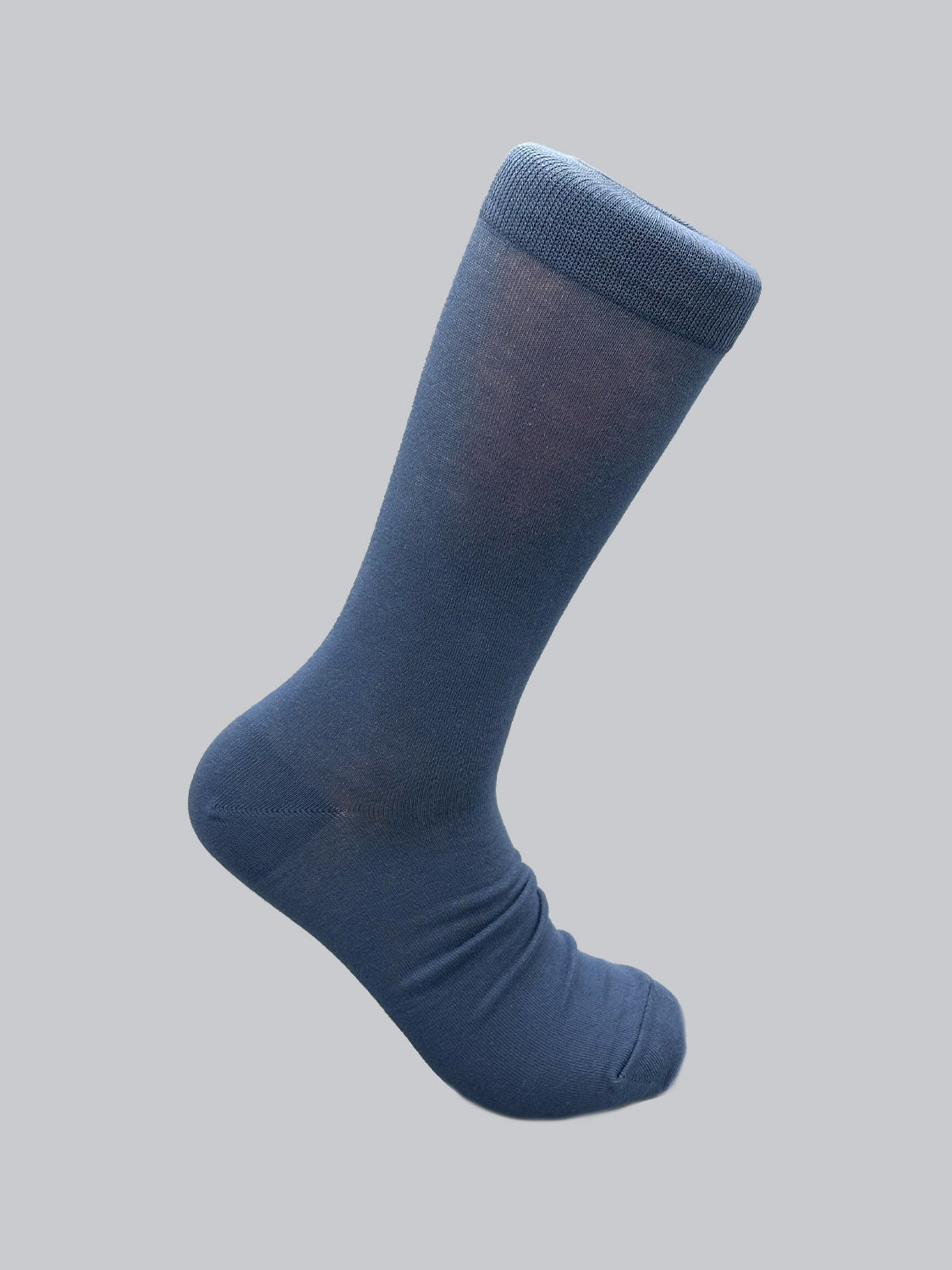A single blue ID Cotton Sock by ID Menswear is shown on a light gray background, foot section pointing left and slightly elevated. It features a smooth texture with a ribbed cuff, ideal for breathable all-day wear.