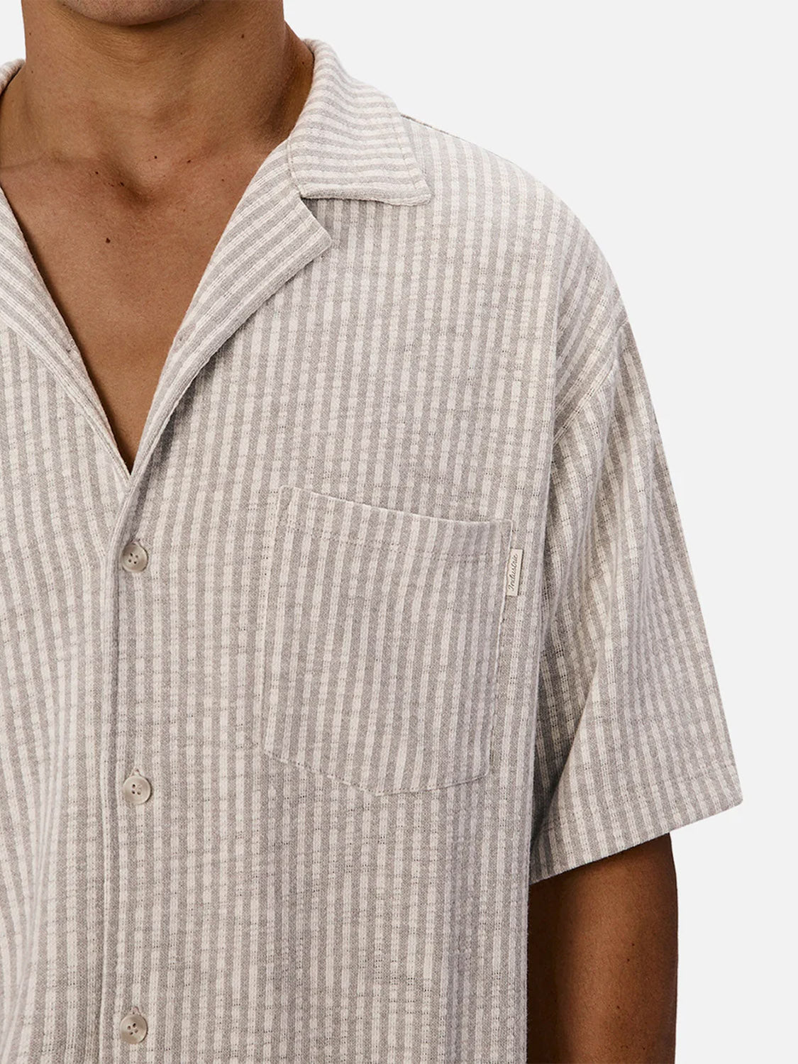 A person wears the Industrie Sonora Short Sleeve Shirt in light gray and white vertical stripes, featuring a collar and chest pocket—shown from shoulders to mid-torso against a white background. A breathable cotton choice for summer.