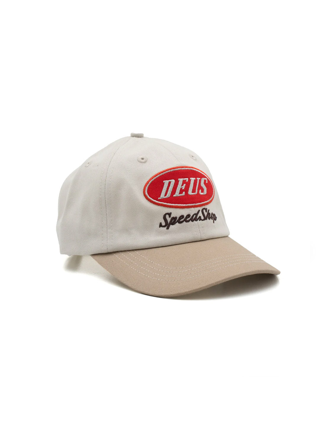 The Deus Speedshop Cap is a beige cotton twill dad hat with a tan brim, red oval DEUS patch, black Speed Shop embroidery, and an adjustable strapback closure.