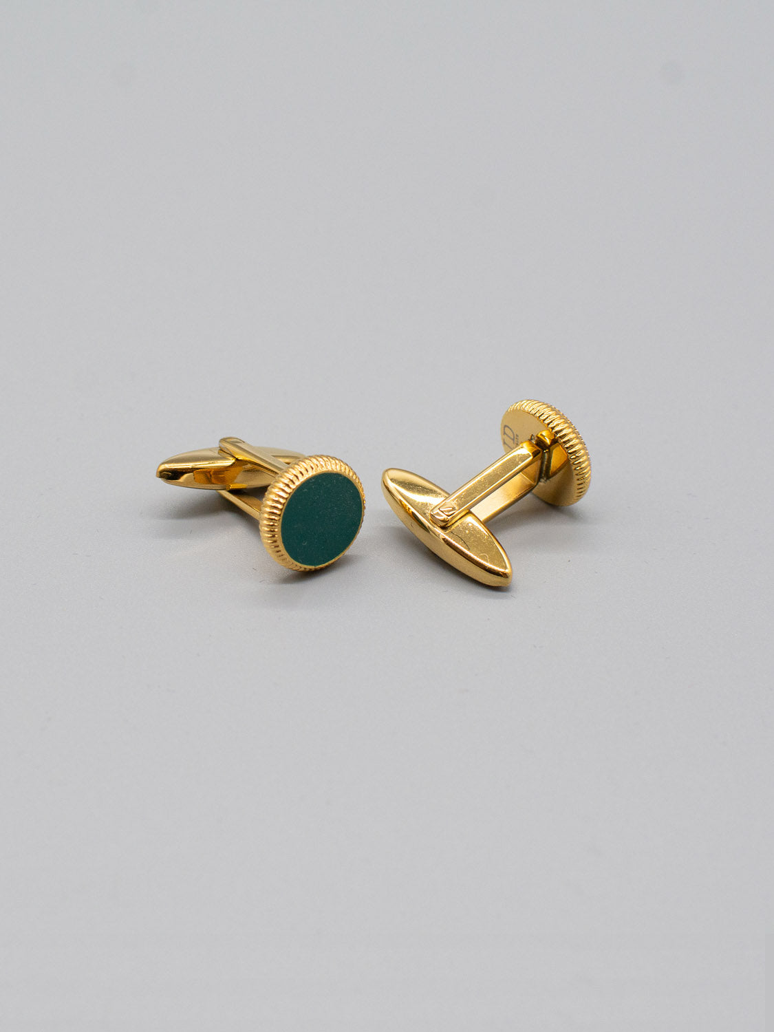 Displayed on a neutral background, the Gold Plated Steel Enamel Cufflinks by ID Menswear feature round green enamel centers with detailed edging and a smooth, shiny finish, perfect for complementing formal attire.
