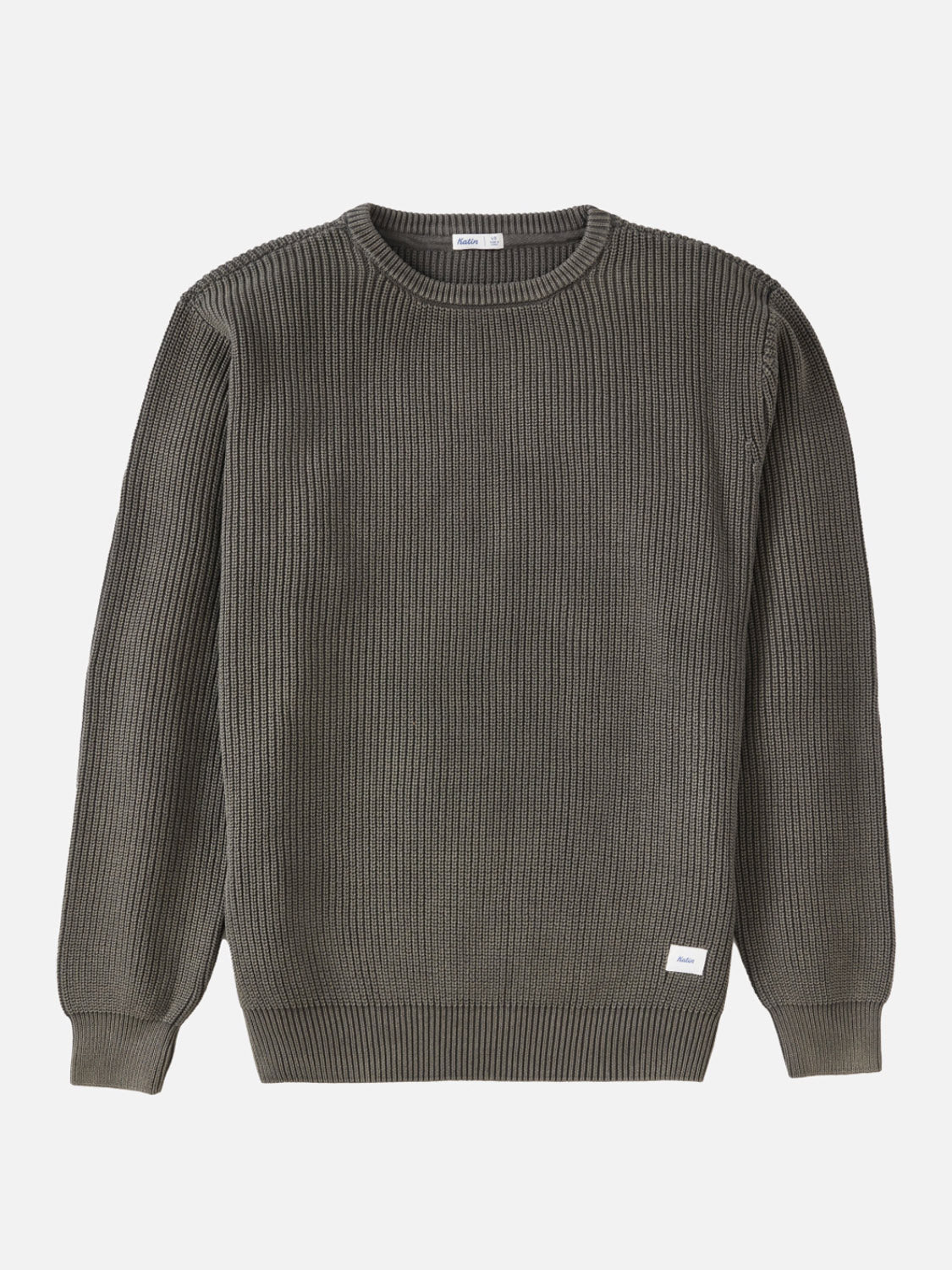 The Katin Swell Sweater is a ribbed, long-sleeve crew neck in olive green, shown laid flat on a white background. A small white tag accents the lower left hem, enhancing this vintage-wash essential.