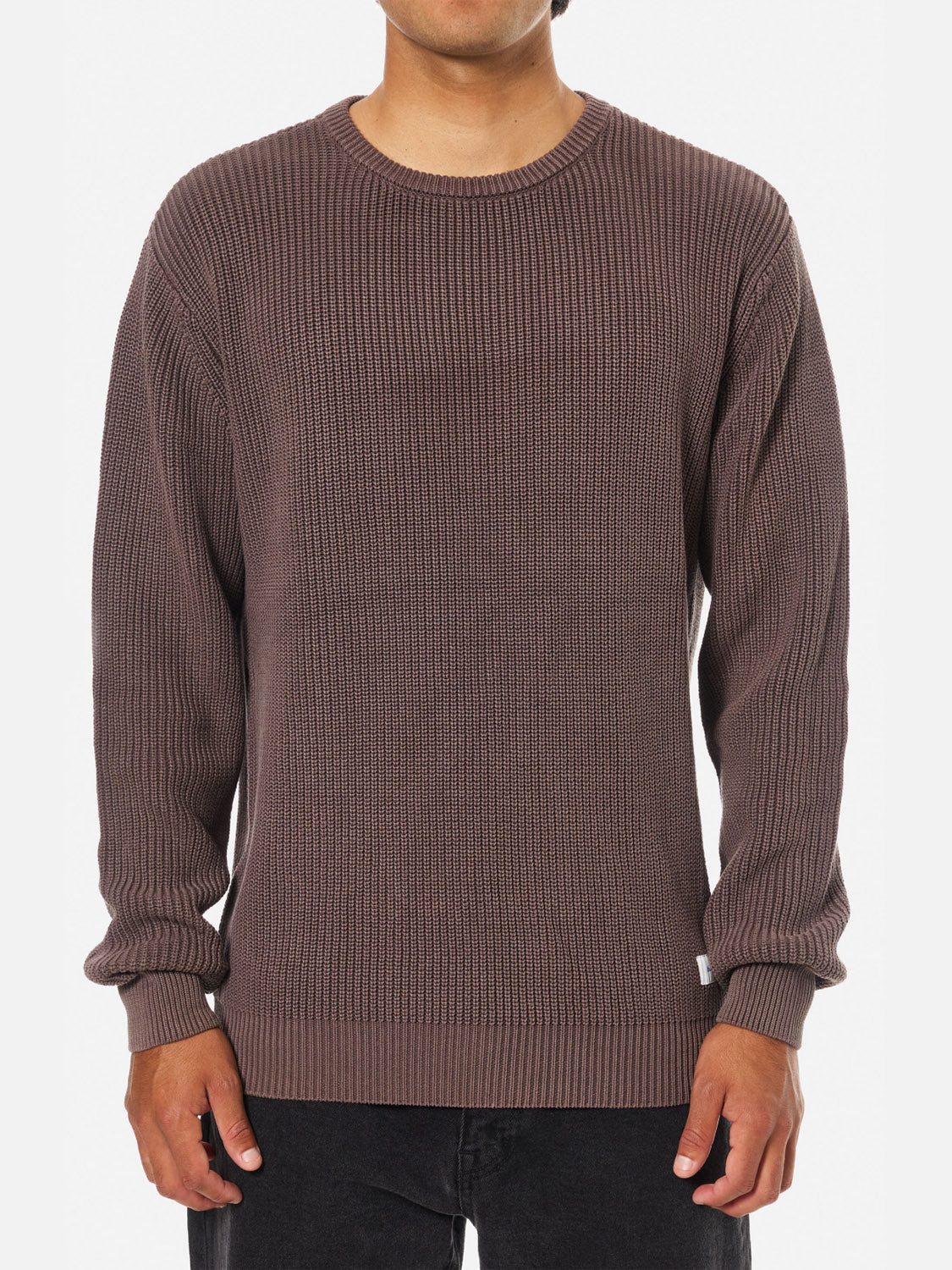 A person stands facing forward against a white background, wearing Katin’s Swell Sweater—a long-sleeve, ribbed, vintage-wash sweater with a crew neckline, relaxed fit, and black pants for a classic, timeless look.