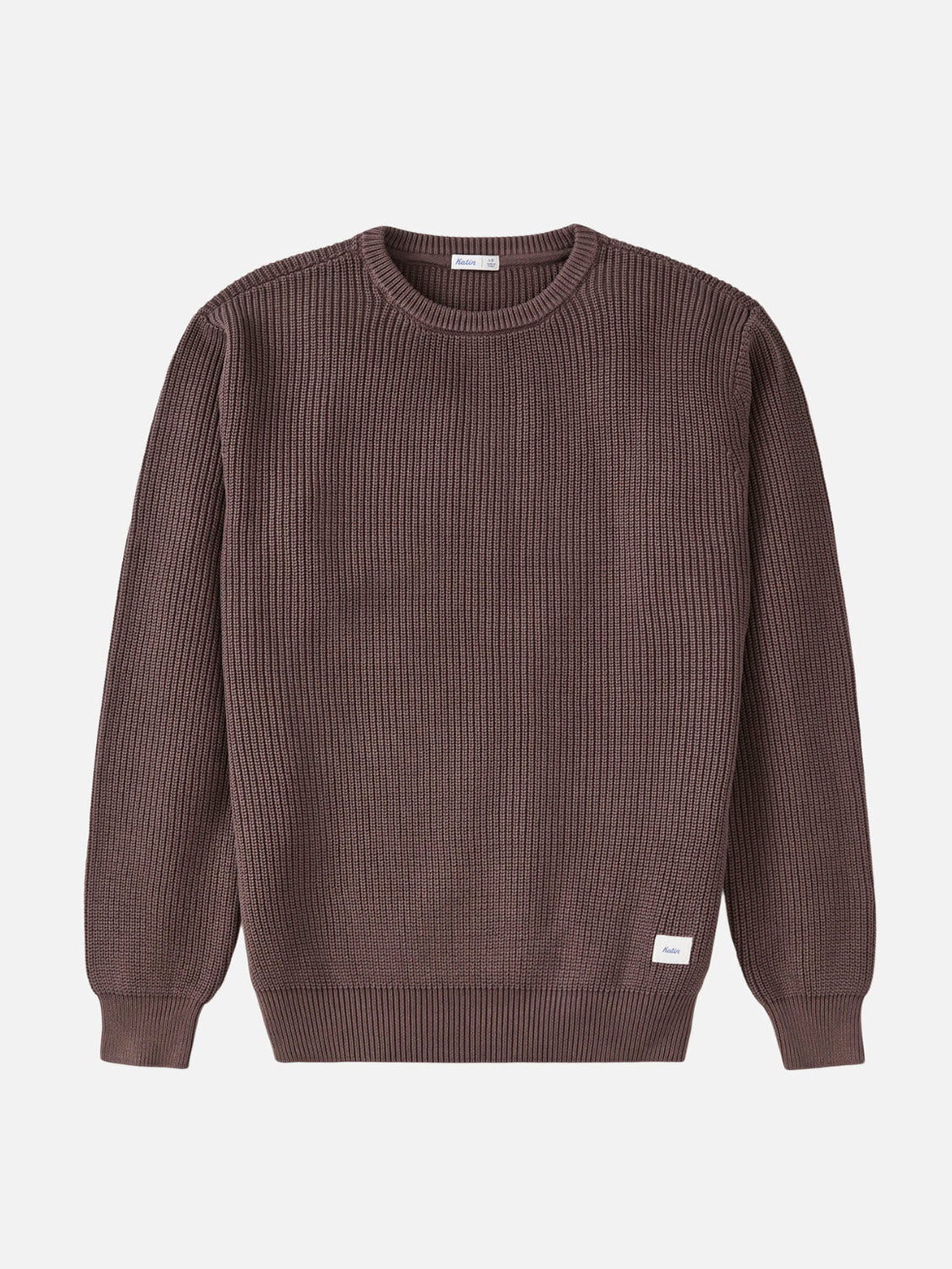 The Katin Swell Sweater is a brown, long-sleeve, ribbed knit cotton crewneck featuring a small white tag on the lower hem, shown against a plain white background.