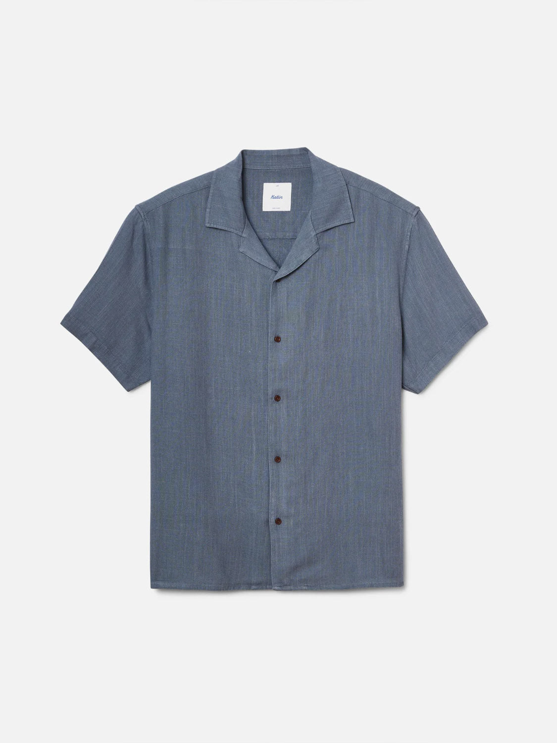 The Katin Teller Shirt is a short-sleeve, button-up camp collar shirt featuring a slub texture in medium blue with dark buttons, shown flat on a white background.
