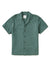 The Katin Teller Shirt is a short-sleeved, button-up shirt in dark green, made from a rayon linen blend. It features a camp collar and dark buttons down the front and is laid flat on a white background.