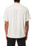 A person in a light beige Katin Teller Shirt, made from rayon linen blend and featuring a camp collar, is seen from the back. Their right arm displays an intricate sleeve tattoo, paired elegantly with sleek black pants.