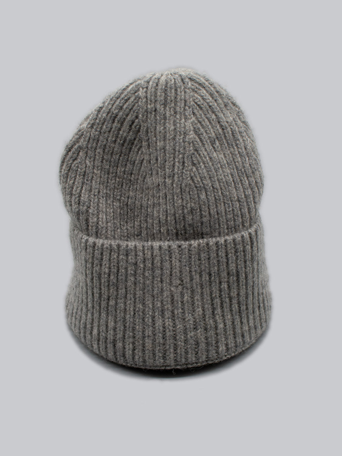 The Telluride Wool Beanie by ID Menswear showcases a ribbed texture and folded brim, providing natural insulation and comfort in a light gray shade.