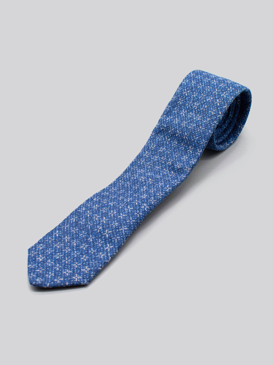 The Japanese Printed Blue Kross Tie by ID Menswear is a handmade 100% cotton necktie in blue with a subtle white pattern, shown on a light gray background.