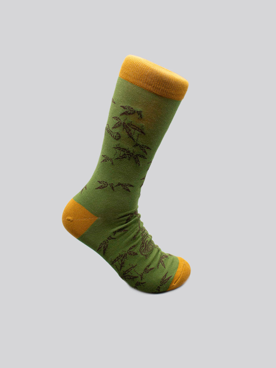 Introducing Tiger Graphic Socks by ID Menswear: limited edition socks in green with yellow toe, heel, and cuff, made from soft combed cotton and featuring a bold tiger graphic on a light gray background.
