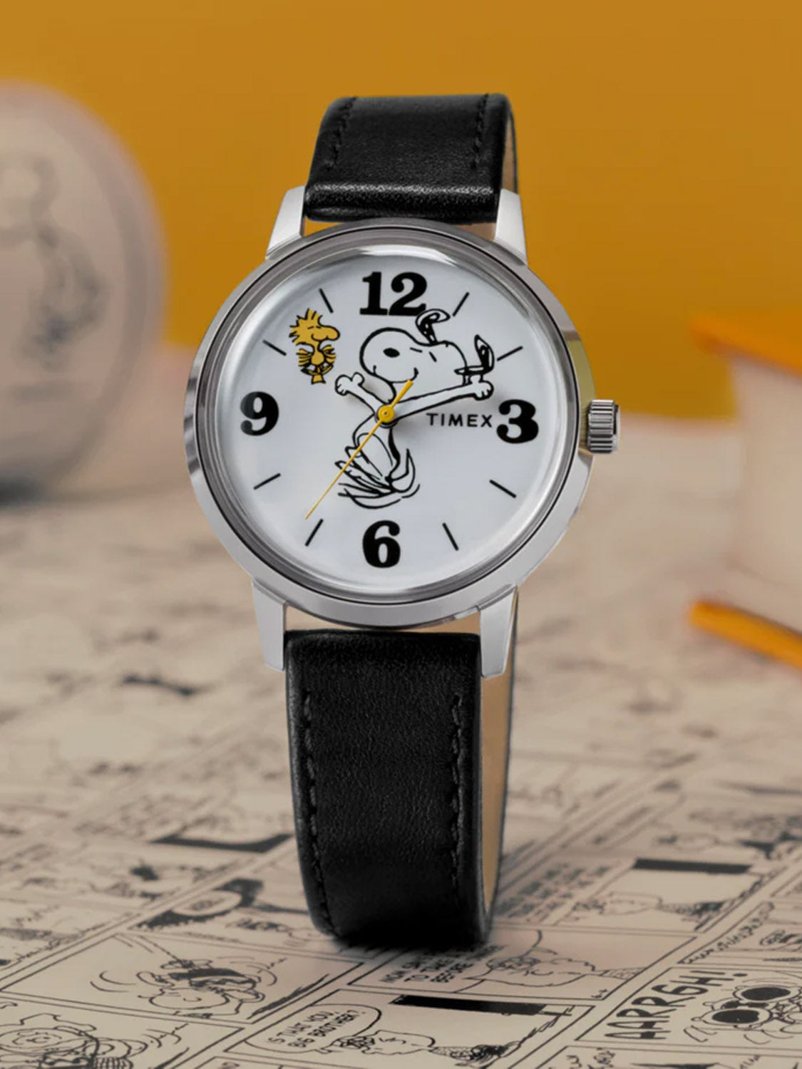 The Timex x Peanuts® Marlin® 75th Anniversary Edition 38mm Leather Strap Watch features Snoopy and Woodstock on a white dial, with Snoopy’s arms as the watch hands, set against a comic strip backdrop to celebrate Peanuts 75th anniversary.
